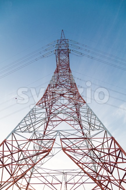 Perspective view under a huge red electricity supply pylon Stock Photo