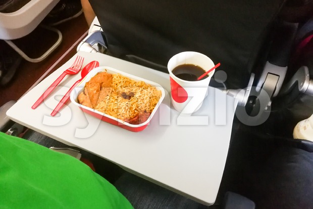 Simple in-flight meal of rice, meat, coffee in disposable utensils Stock Photo