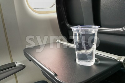 Disposable refreshing mineral water on table in air plane cabin Stock Photo