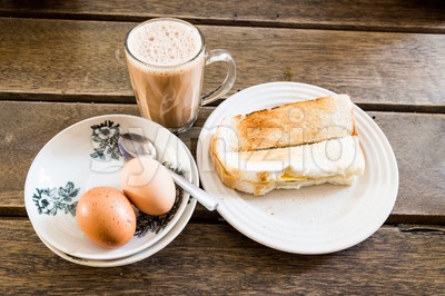 Popular Malaysian breakfast teh tarik, toast bread and half-boiled egg Stock Photo