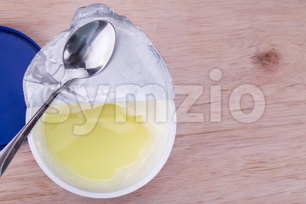 Layer of whey protein formed on top of packaged yogurt Stock Photo