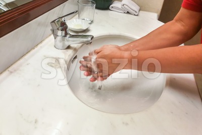 Person washing hands  with running water from tap faucet Stock Photo