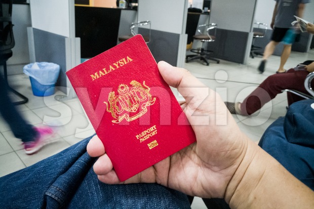 Person holding Malaysia international passport Stock Photo