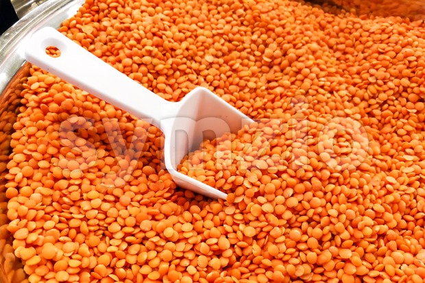 Heap of organic red dal with ladle in bucket Stock Photo