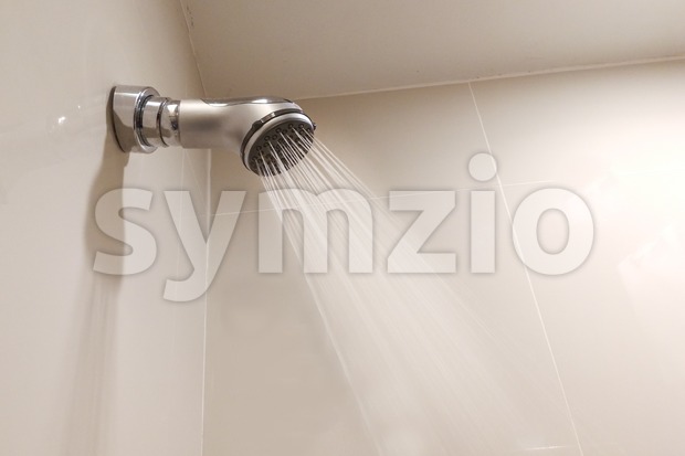 Shower head with refreshing water droplets spray in bathroom Stock Photo