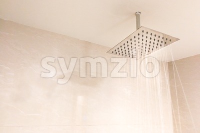 Shower head with refreshing water droplets spray in bathroom Stock Photo