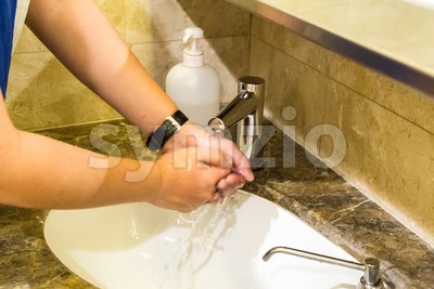 Person washing hands with anti bacterial liquid and water Stock Photo