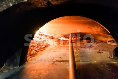 Italian pizza being baked in traditional wood flame fire oven Stock Photo