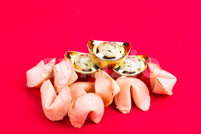 Fortune cookies with decorative gold nuggets on red background Stock Photo