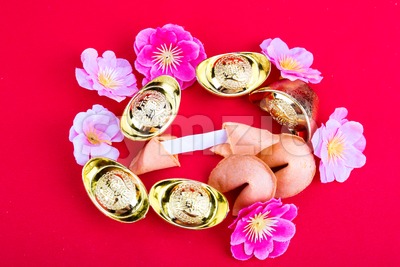 Fortune cookies, decorative gold nuggets, plum blossom flowres red background Stock Photo