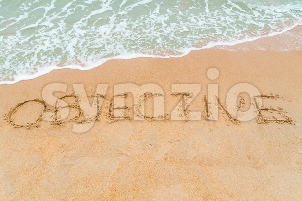 OBJECTIVE inscription written on sandy beach with wave approaching Stock Photo