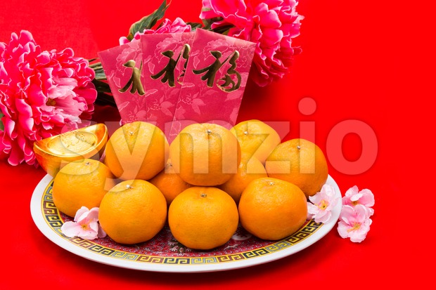 Mandarin oranges and red packets with Chinese Good Luck character Stock Photo