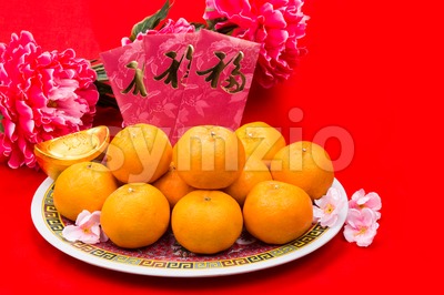 Mandarin oranges and red packets with Chinese Good Luck character Stock Photo