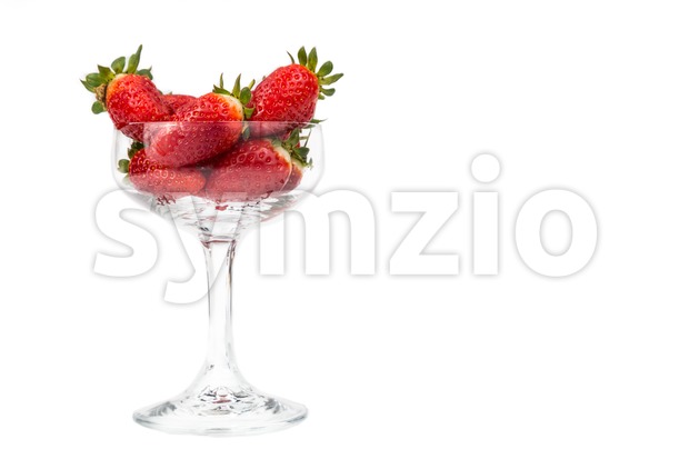 Juicy strawberries in a transparent cocktail glass with white background Stock Photo